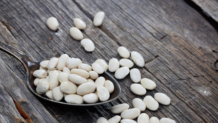 Fototapeta na wymiar White haricot beans on an old wooden table