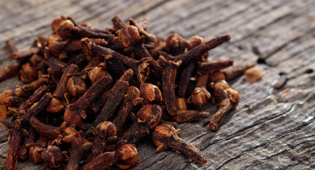 A heap of cloves on a wooden table, copy space
