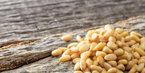 Dried pine nuts seeds on an old wooden table, copy space
