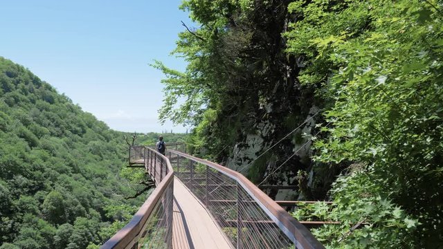 Young woman walks on observation deck. Okatse Canyon, near Kutaisi, Georgia