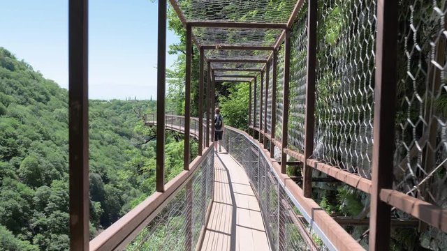 Young woman walks on observation deck . Okatse Canyon, near Kutaisi, Georgia