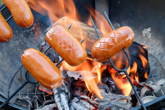 Preparing sausages on camp fire