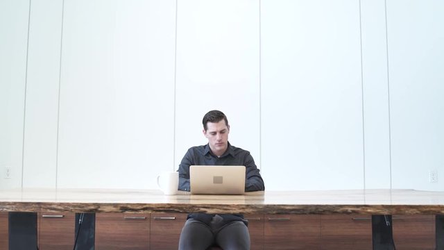 Medium wide shot of a man using a laptop