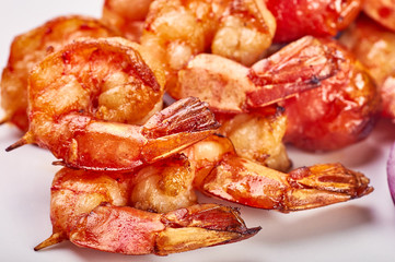 Appetizing fried shiny huge shrimp. Shish kebab from shrimps on skewers for a holiday. Grilled prawns on a white background isolate. Catering table for a wedding, a holiday.