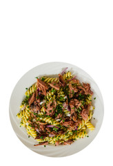 pasta fusilli salad with tuna and onion in white plate with copy space. top view. isolated on white