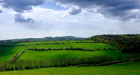 Obraz premium Green field and cloudy sky