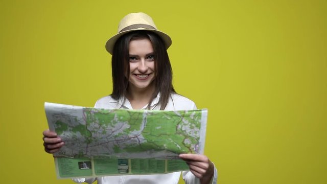 Happy woman holding a map - isolated over a white background