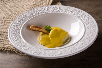Ravioli stuffed with curd cheese in pumpkin sauce