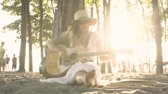 A young woman singing and playing the guitar