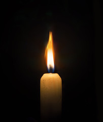 Single lit candle with flame on black.