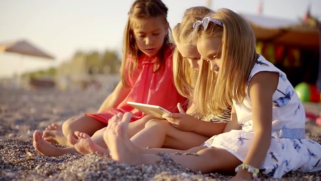 Sideview shot of three girls relaxing on the beach