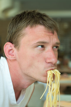 A Young Guy Eating Noodles