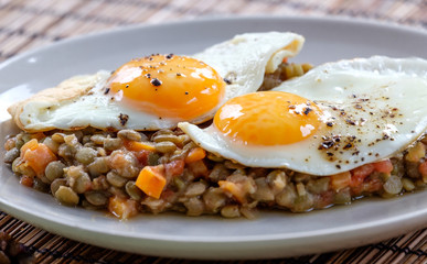 Delicious lentils with vegetable and fried egg close up