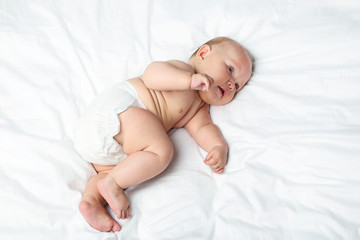 Little newborn baby on white bed