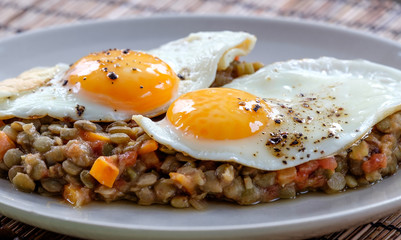 Delicious lentils with vegetable and fried egg close up