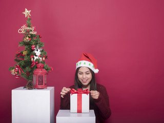 Beautiful Santa Claus girl in studio on red background, Christmas concept