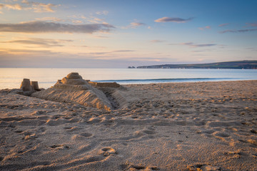 sandcastle on beach at sunrise