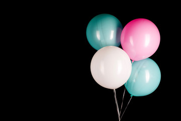 white blue pink balloons on a black background