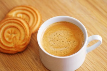 Cup of coffee with homemade butter cookies on a rustic wooden background for a breakfast in the morning or break time in the afternoon.