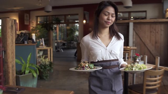 Tracking shot of a waitress serving food