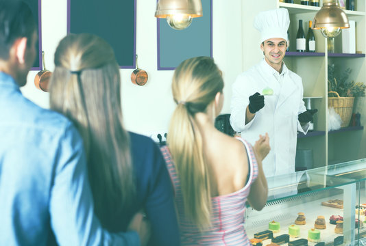 Cheerful chef man is serving visitors