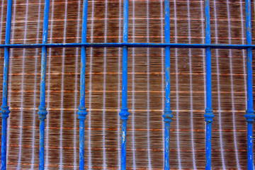 Window. Metal old blue lattice. Wooden texture. Architecture.