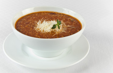 hot and spicy beef soup with cheese in a bowl