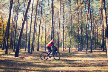 the girl is riding a bicycle through the woods