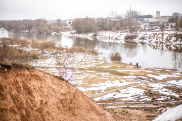River Musa in winter.  Snovy and smoky day. On the coast fisherman catching fish. Bauska, Latvia