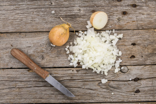 White Onions (dices) on wooden background; selective focus