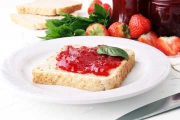 Fresh raspberry jam with toast or bread for breakfast.