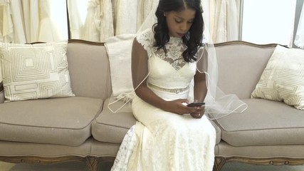 Medium shot of a woman using a smartphone in a bridal salon