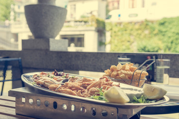 Sea food served at outdoor restaurant with city view.