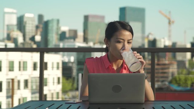 Medium shot of woman using laptop outside