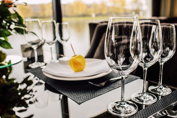 Sparkling glassware stands on long table prepared for wedding dinner