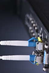 Network devices technology, optical fiber cable and switch, close-up on black background