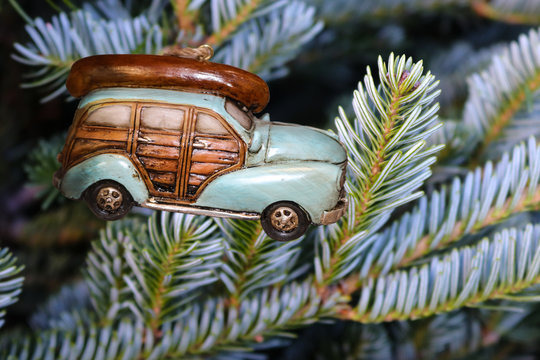 Retro Christmas ornament - A woody car with a canoe on top hanging on silver spruce tree