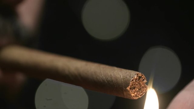Close Up Man Lights Cigar Slow Motion. a close up view of a mans lower face with a cigar and a lighter lights it