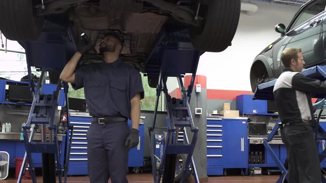 Jib shot of a mechanic examining a car