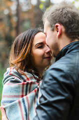Fototapeta premium the guy with the girl walking in autumn Park. cool , snuggle under a blanket