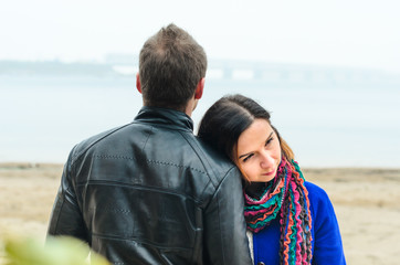 the guy with the girl walking in autumn Park. deserted beach , dirty sand .stand back .