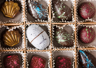 Colored chocolate candies. Creative candy in a box on a gray background.