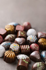 Colored chocolate candies. Creative sweets on a gray background.