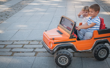 Funny boy car driver with sister steering wheel on car toy