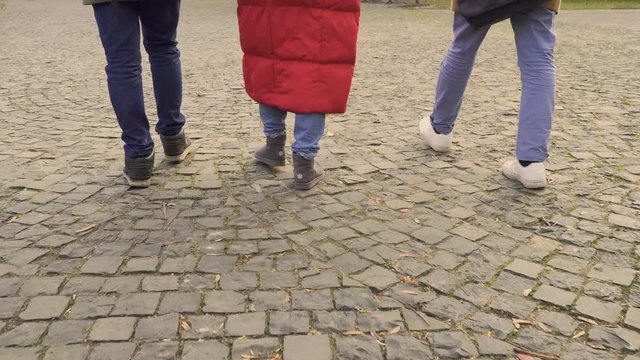 Three young people walking on pavers stones