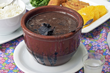 Feijoada served at the table with its typical accompaniments
