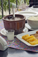 Feijoada served at the table with its typical accompaniments