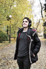 Fototapeta premium A young man in the park litening to music