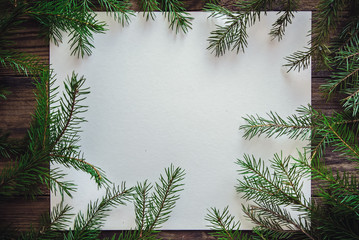 Christmas wooden background with sheet of paper and fir branches