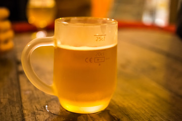 Frosty glass of light beer on the bar counter. Beer tap